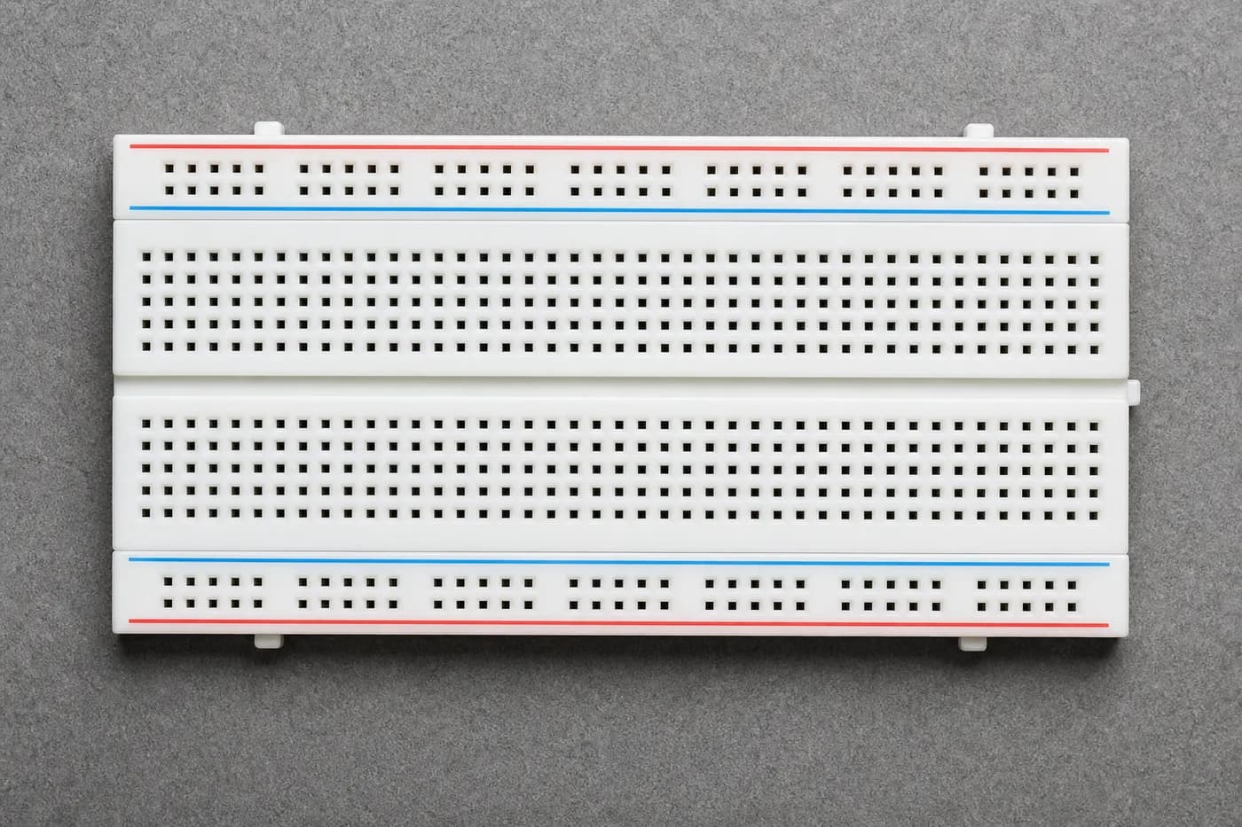 White breadboard showing power rails and component sections for beginners