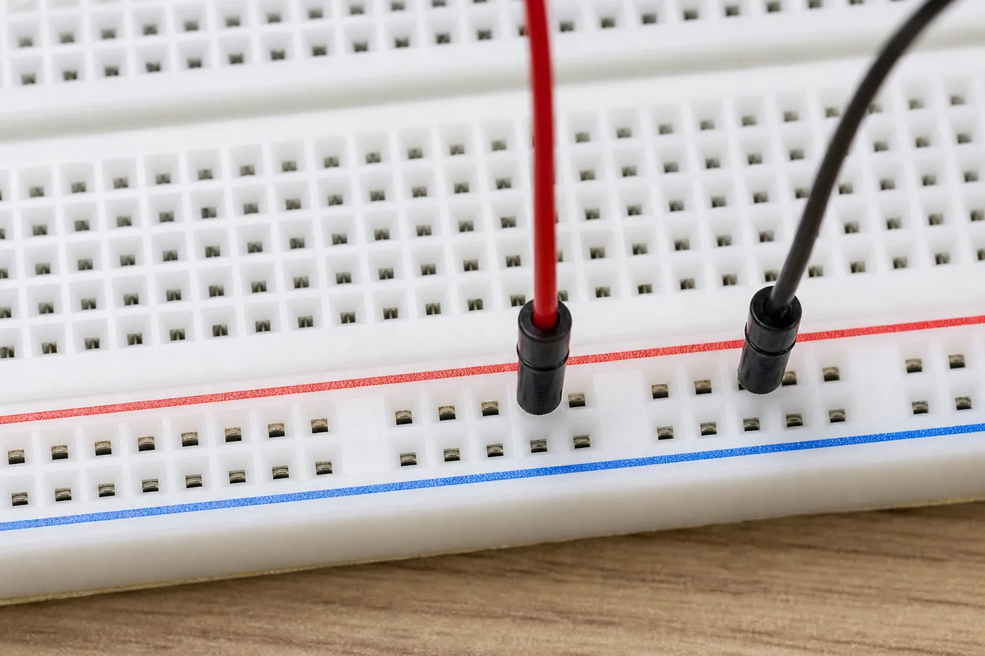 Horizontal power rails on a breadboard with red and blue jumper wires